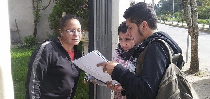 Estudiantes realizando la encuesta a una ciudadana