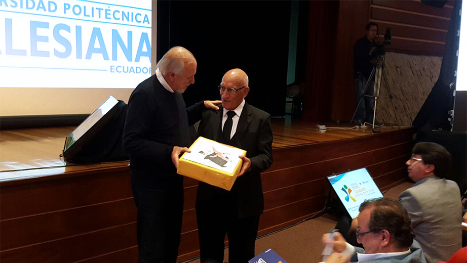 Rector de la UPS, P. Javier Herrán (der) recibe un presente de Claudius Ceccón, director del Centro de Creación Imagen Popular (CECIP) de Brasil