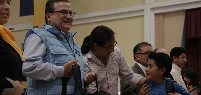 Vicerrector de la UPS Quito, José Juncosa y Edgar Andrade del MIES entregan las mochilas escolares.