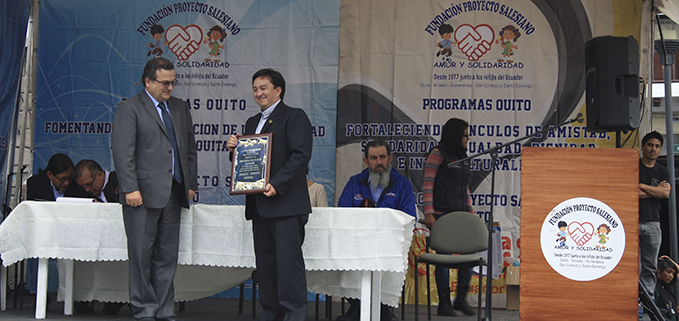 P. Robert García, Vicario Inspectorial, entrega un diploma y una placa de reconocimiento a José Juncosa, vicerrector de la sede Quito.