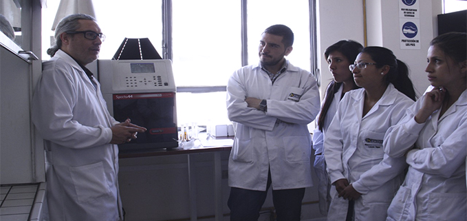 Profesor Christian Larenas (der.) y estudiantes en los laboratorios de Ingeniería en Biotecnología de los Recursos Naturales