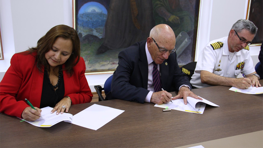 Firma del convenio por parte de Verónica Massón (izq.), Padre Javier Herrán y Cmte. Brúmel Vázquez Bermúdez