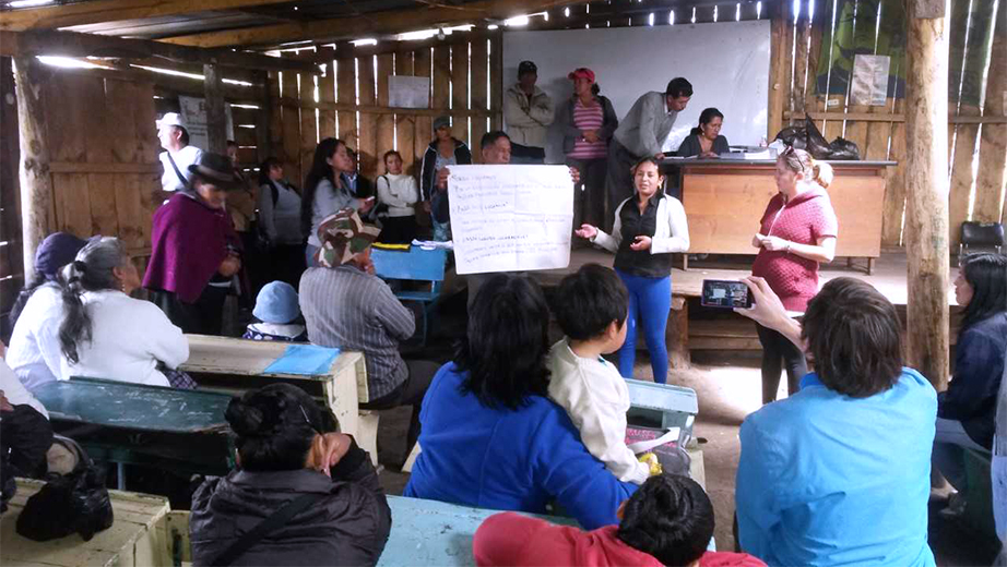 Pobladores de la comunidad de Los Pinos durante una asamblea en compañía de docentes de la UPS