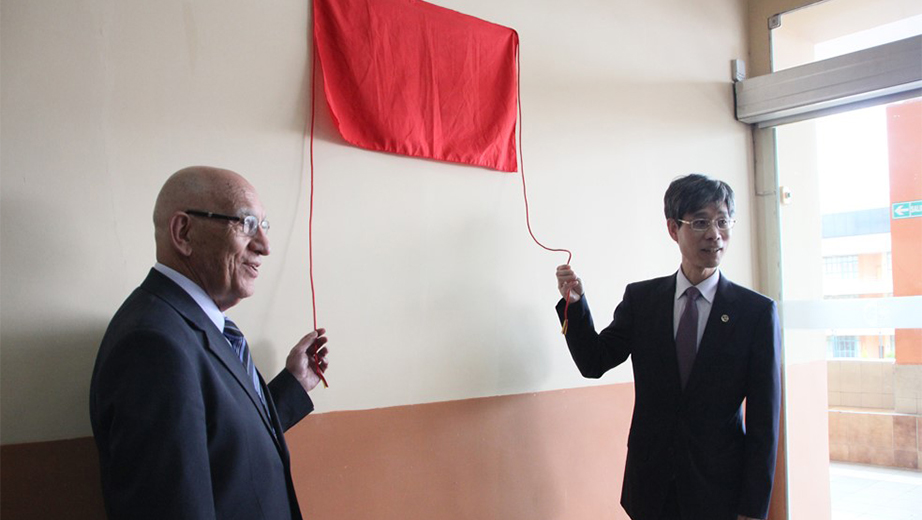 Rectores de la UPS y CTBU, P. Javier Herrán (izq.)  y Ph.D. Sun Fangcheng develando la placa conmemorativa de la alianza en el laboratorio de Ingeniería Mecánica