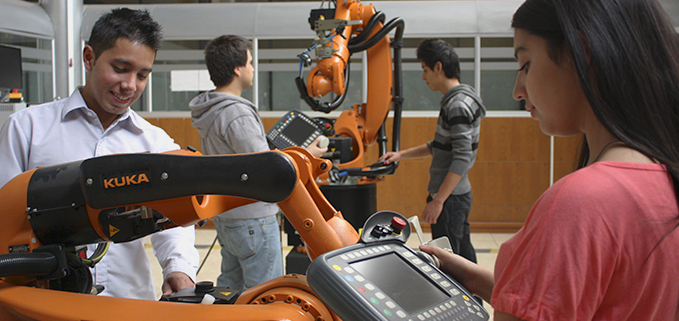 Estudiantes de la Sede Cuenca, con los brazos robóticos KUKA.