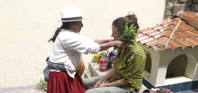 Curandera realizando ritual de la limpia a una participante.