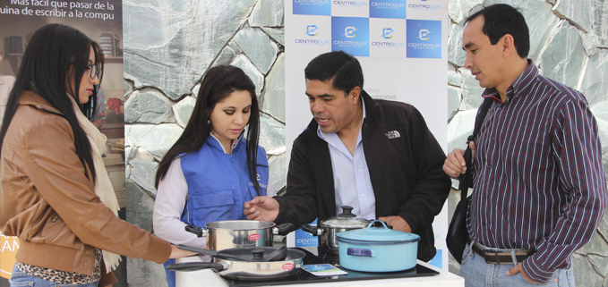 Funcionaria de la Empresa Eléctrica Regional Centro Sur presentando las cocinas de inducción a docentes de la UPS