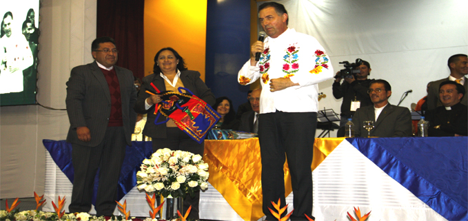 P. Ángel Fernández viste la camisa otavaleña, regalo de los colegios salesianos asistentes al Coliseo de la UPS.