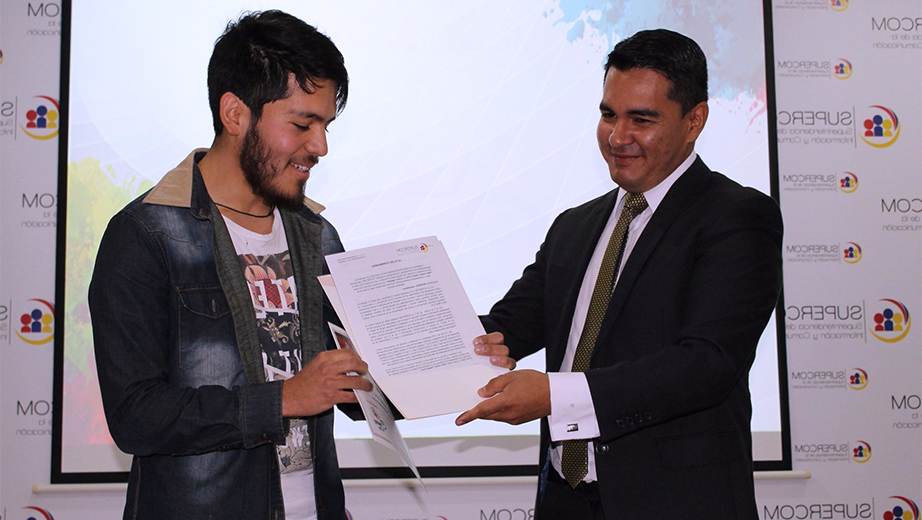 Pablo Vásquez recibiendo el premio por parte de Luis Enrique Zamora, Intendente de la Zona 6- Austro Supercom