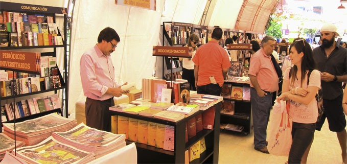 Dr. Hernán Hermosa revisa los textos en  uno de los pabellones del salón iberoamericano del libro universitario en Medellín.