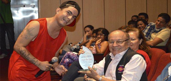 Gabriel Gallardo (izq.) entrega placa de reconocimiento Miguel Silva (der) por sus años de trayectoria en el teatro.