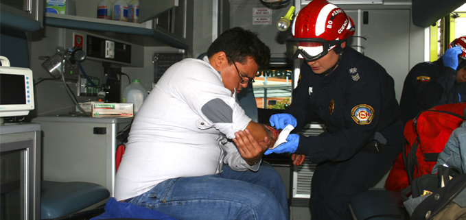 Paramédica del Cuerpo de Bomberos Voluntarios de Cuenca presta los primeros auxilios a un herido (simulación).