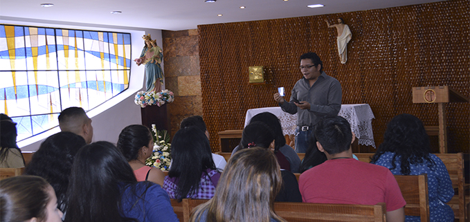 Juan José Rocha realizando la entrega de estampillas de María Auxiliadora durante el primer día del Triduo.