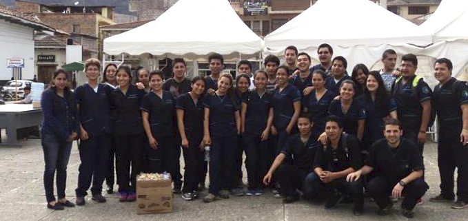 Dos estudiantes que participaron en la campaña de Gualaceo junto a los docentes Mónica Brito y Carlos Mínguez