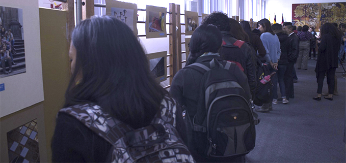 Estudiantes observan las diferentes muestras fotográficas en el auditorio Monseñor Leonidas Proaño.
