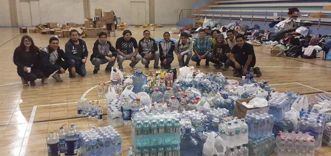 Estudiante que apoyan en la recolección de donativos en el Coliseo Universitario, Centro de acopio de la Sede Cuenca.