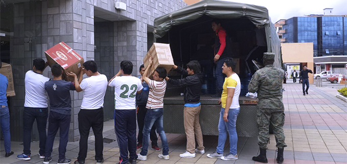 Estudiantes de la UPS colaborando con la carga de los productos donados en el primer camión de las FF.AA.