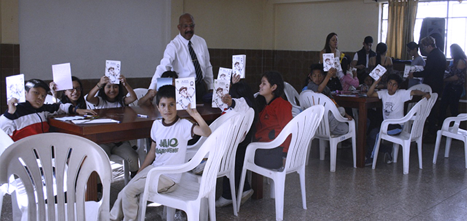 Héctor González del club de Lecto-escritura trabajando con los niños del programa salesiano PACES.