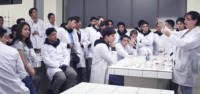 Estudiantes observando una práctica en el laboratorio de Química de la Sede Cuenca.