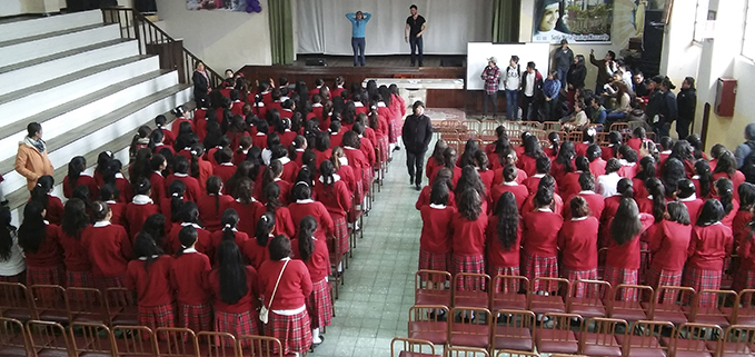 Capta a los estudiantes de la UPS explicando las reglas sobre seguridad en el auditorio de la institución educativa salesiana