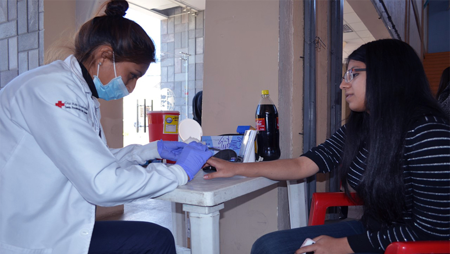 Personal de la Cruz Roja del Azuay atendiendo a una estudiante que dona sangre