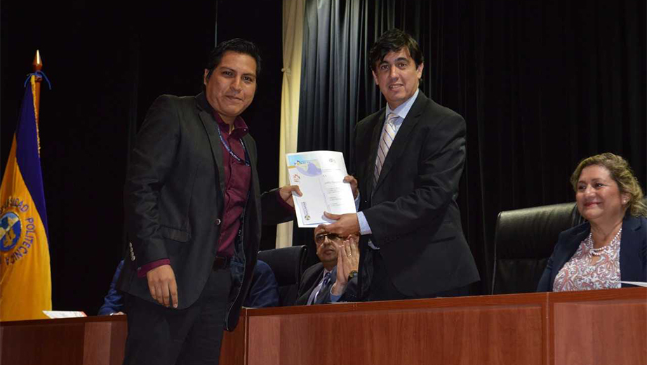 Andrés Bayolo, vice president of UPS's branch in Guayaquil, confers Nicolás Sumba a recognition award