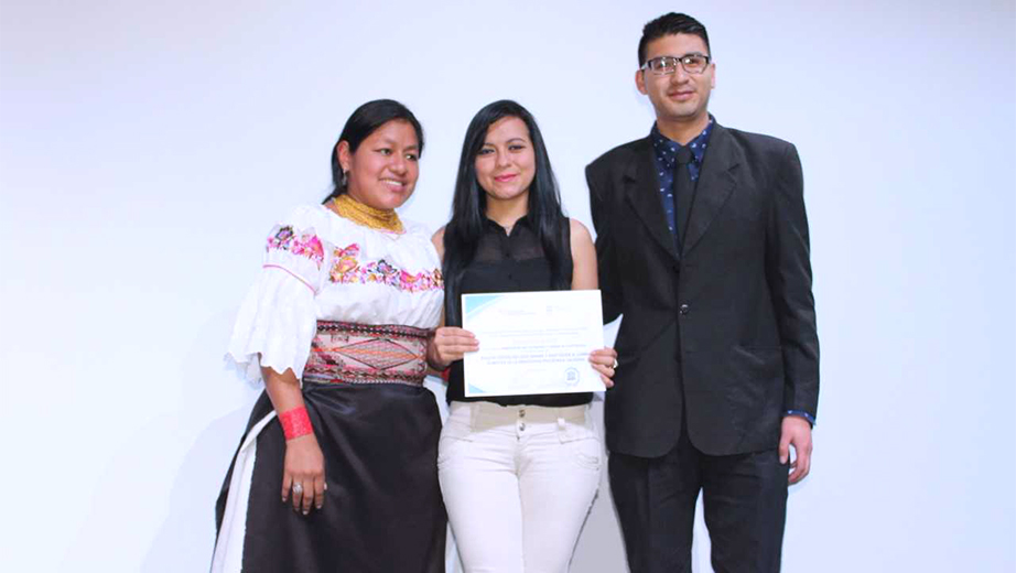 Los estudiantes de la UPS Sandra Pino y Cristian Piguave reciben mención de honor por Yolanda Otavalo, coordinadora de Saberes Ancestrales de la SENESCYT