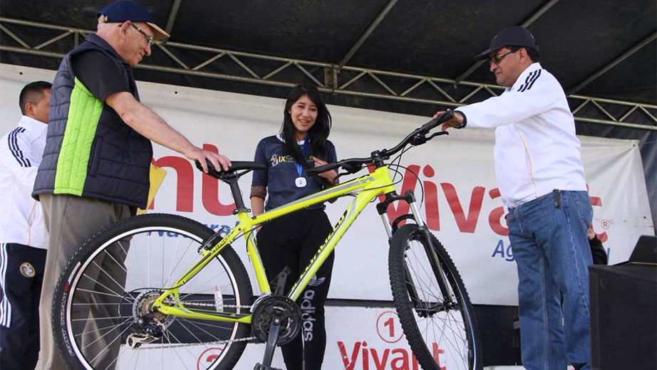 Momento de  la entrega de la bicicleta a la primera ganadora sorteada entre los participante del IX Circuito Atlético Universitario UPS 2017