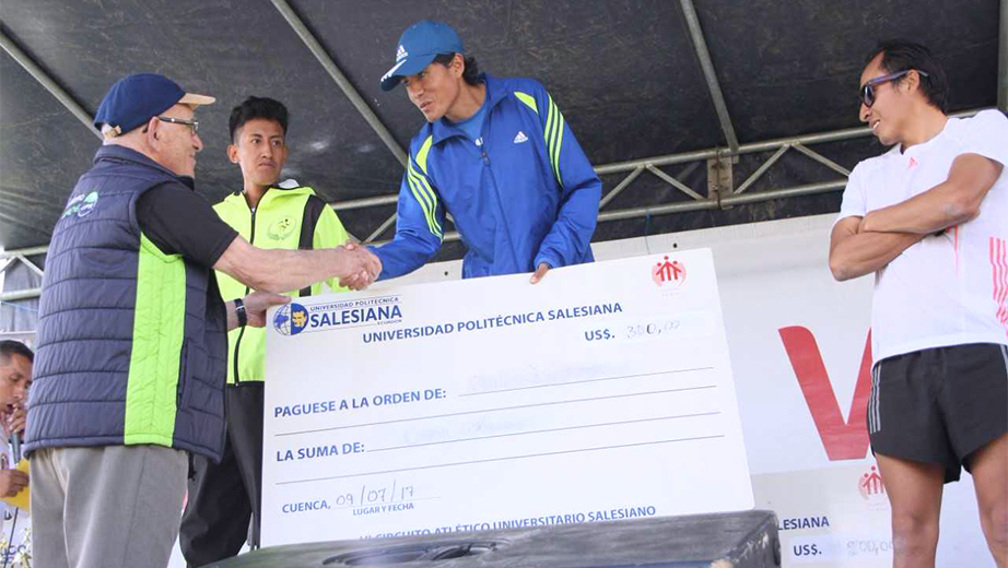 Entrega del premio al ganador general Cristian Vásconez por parte del Padre Javier Herrán Gómez, Rector de la UPS