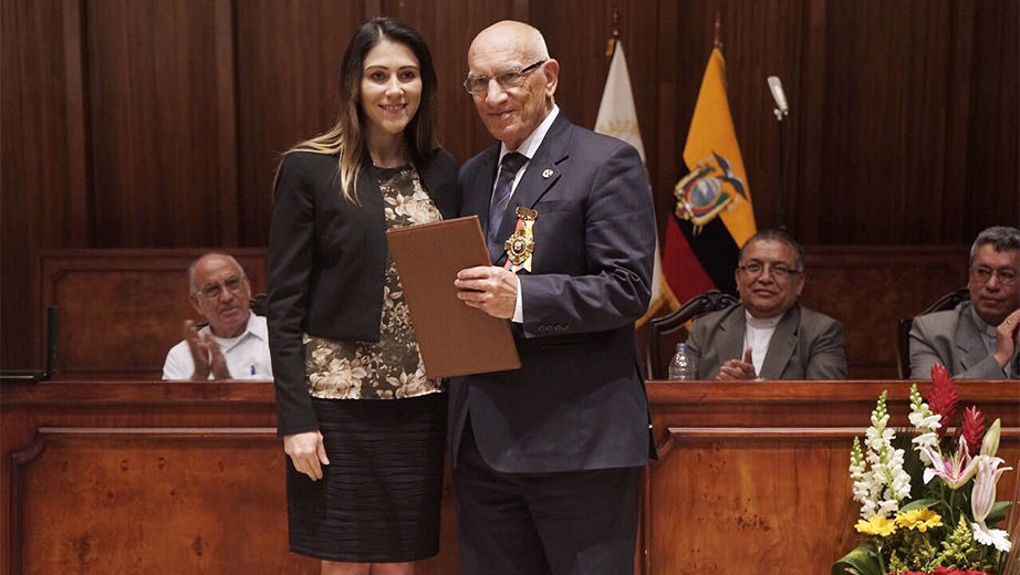 Father Javier Herrán being awarded by Libia Rivas