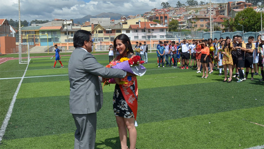 Vicerrector de la UPS sede Cuenca, entrega un ramillete de flores a Samantha Vázquez, Señorita Deportes Copa UPS 2017