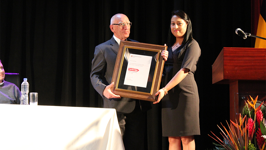 Padre Javier Herrán y Adriana Guanuche recibiendo el logo de Cambridge para su uso en La Salesiana