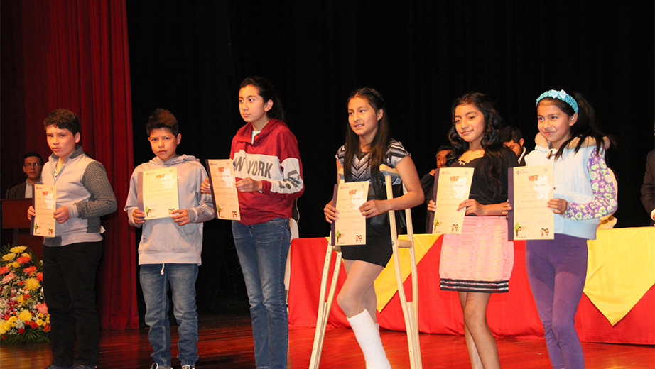 Niños y niñas asistentes al curso recibiendo sus respectivos certificados