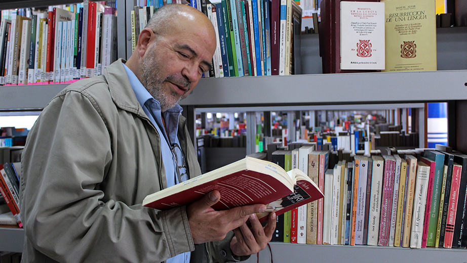 El profesor Fernando Garcés con un ejemplar en la biblioteca de la sede Quito