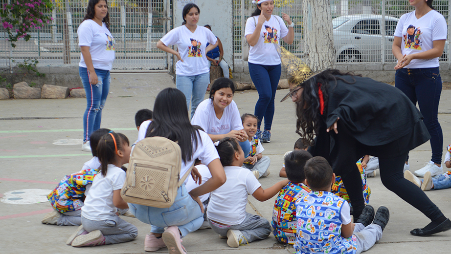 Estudiantes junto a niños y niñas realizando actividades lúdicas