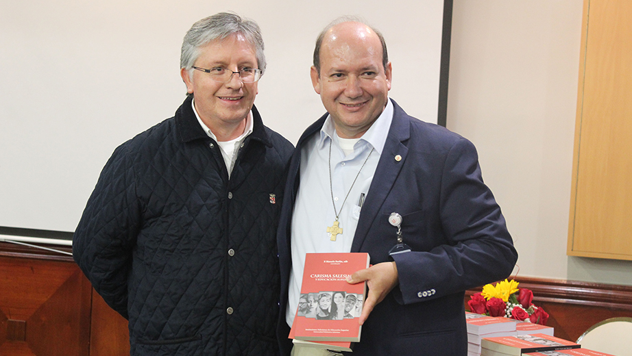 P. Marcelo Farfán (izq.) entrega el libro 