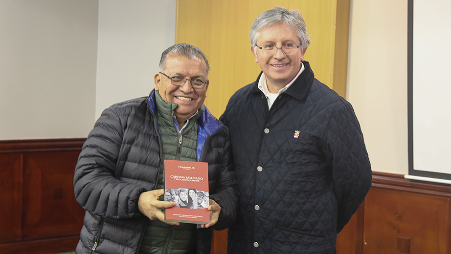 P. Marcelo Farfán (izq.) entrega el libro 