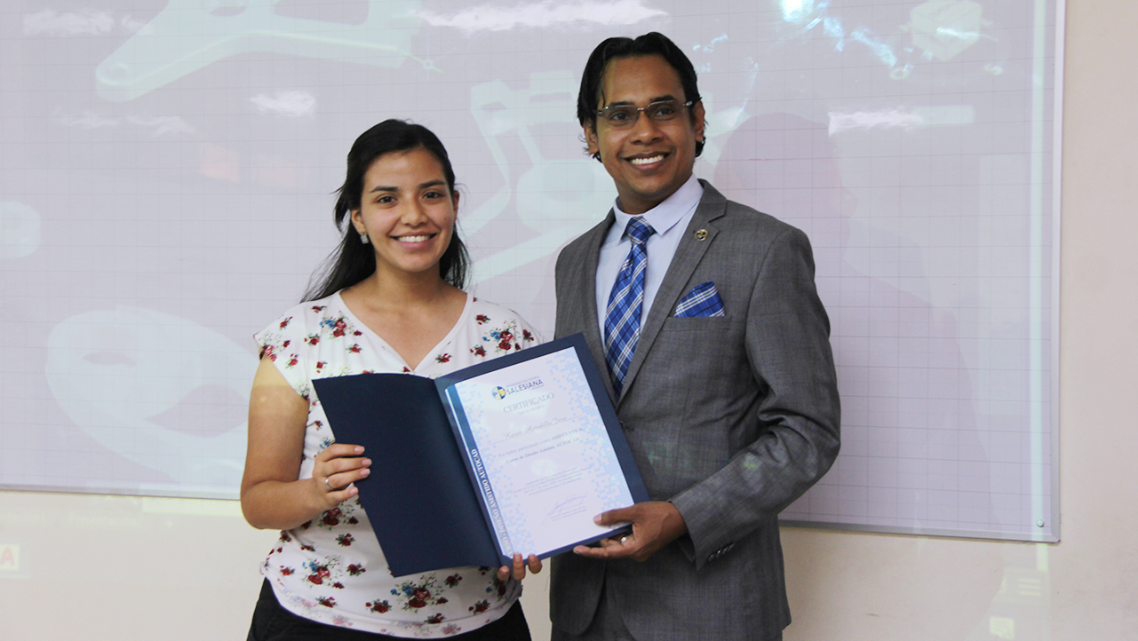 Karen Astudillo recibe su certificado de asistencia de la mano de Gary Ampuño, director de la carrera de Electricidad