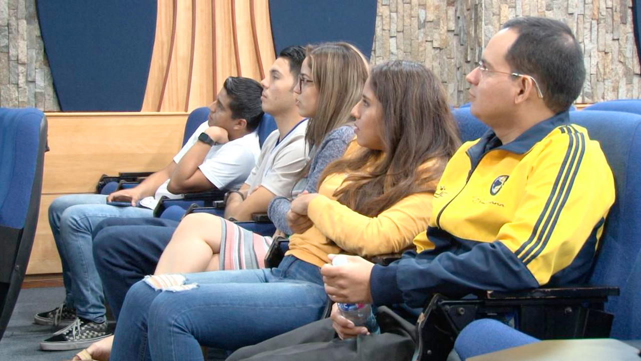 Asistentes al evento observan la exposición de sus compañeros graduados