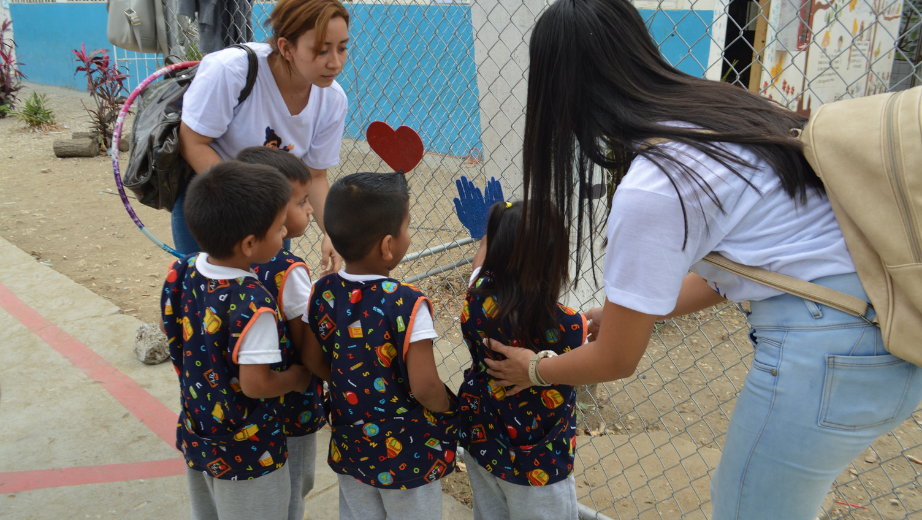 Estudiantes realizando actividades de juego con niños.