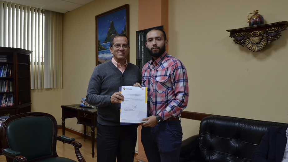 Fernando Moscoso entrega el documento de la beca a Carlos Verdugo.