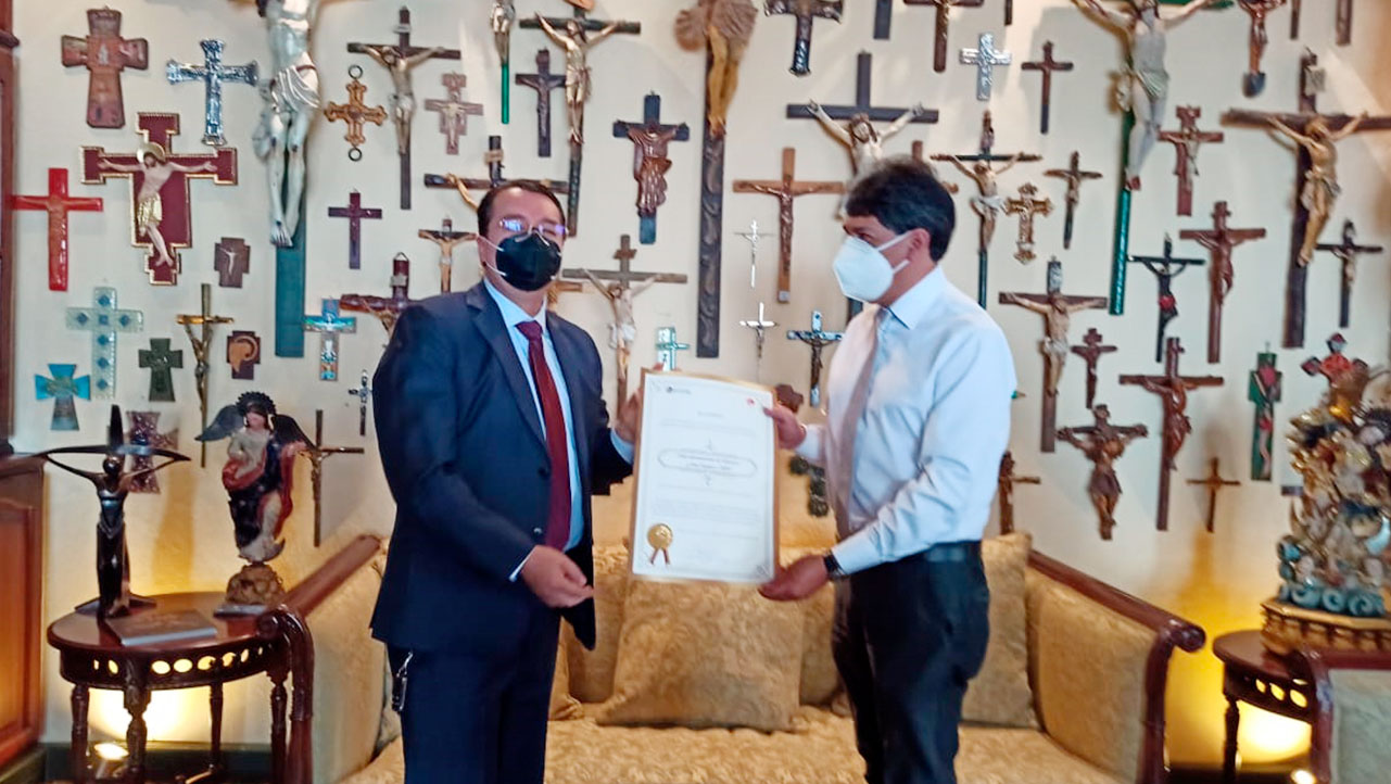 El P. Juan Cárdenas, rector de la UPS hace la entrega del reconocimiento a Fausto Ordoñez, director del CIDAP