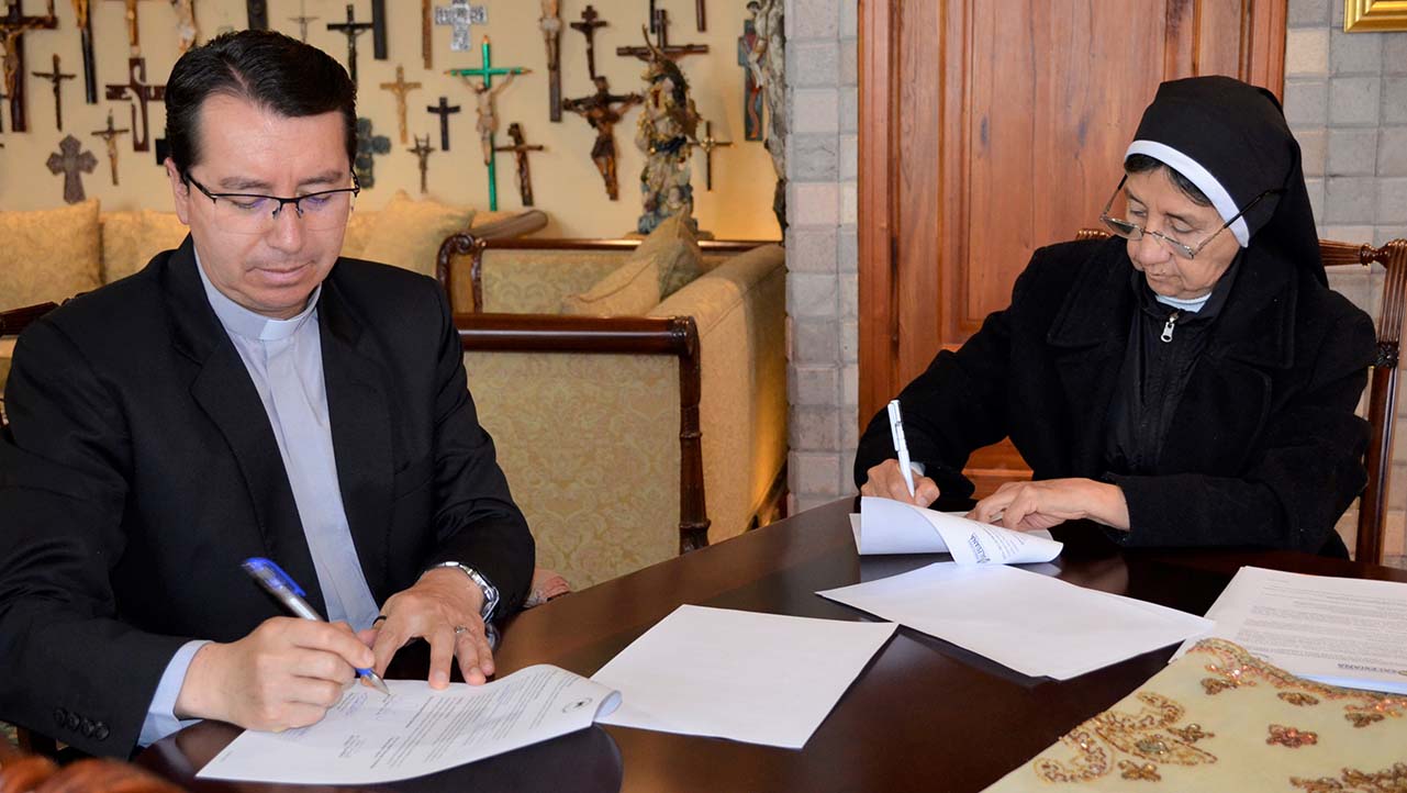 Momento de la firma del convenio por parte del Rector, P. Juan Cárdenas y la Rectora Sor Asteria Vásquez